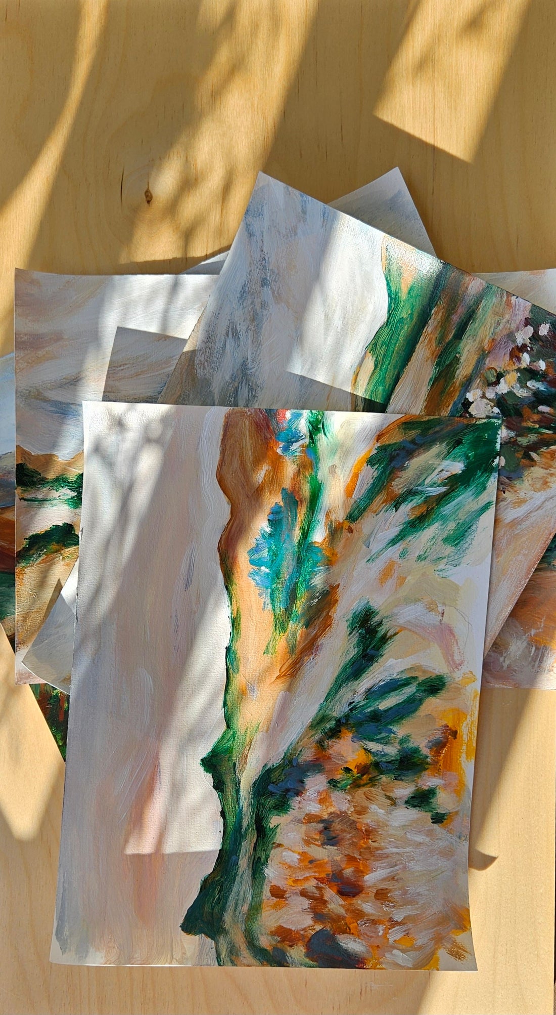Stack of original paintings in dappled light