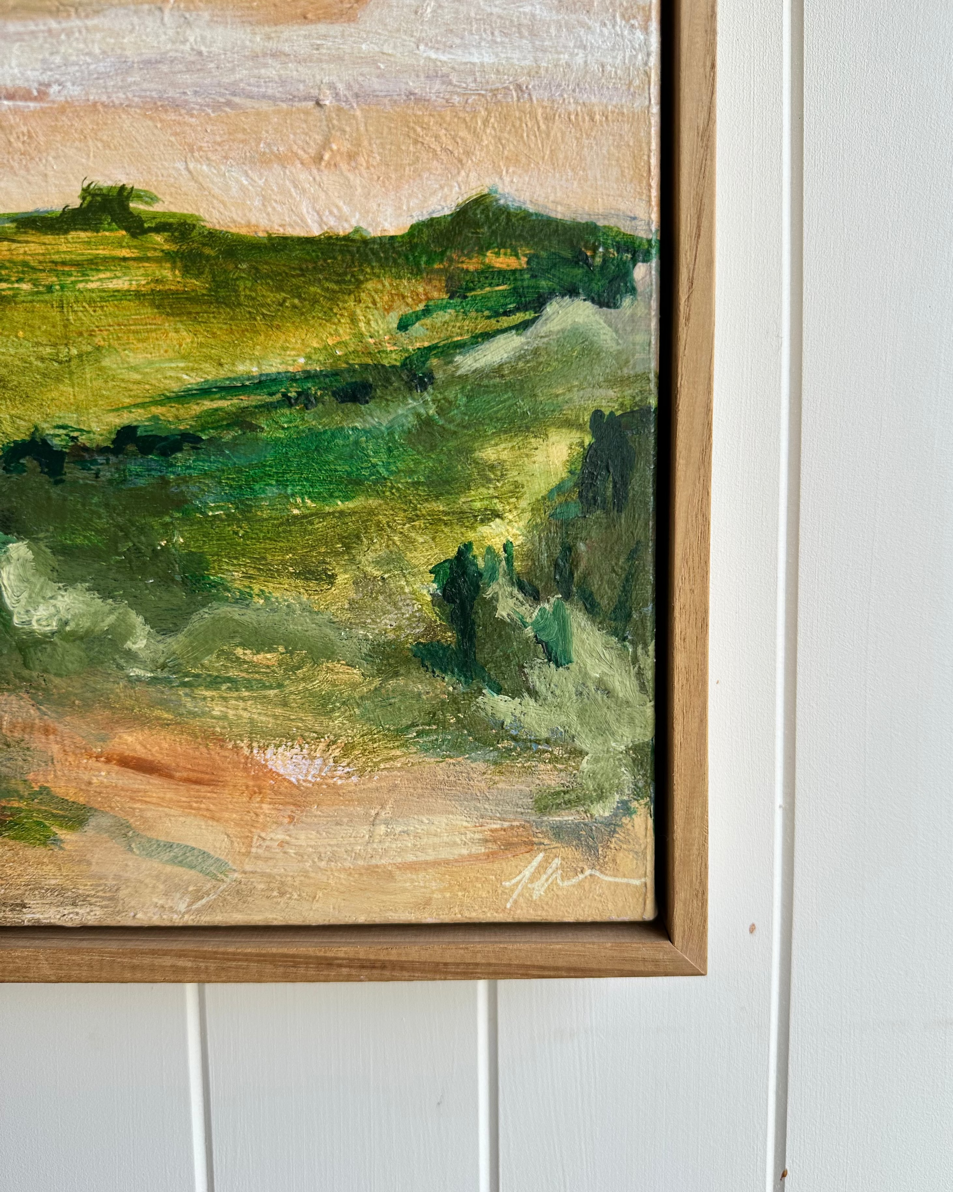 Framed landscape painting on a white wall